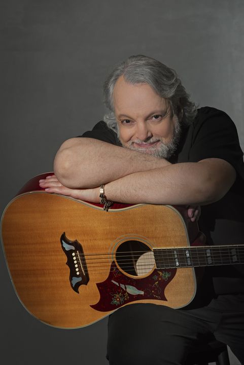 Dado appoggiato alla chitarra acustica, ritratto sorridente